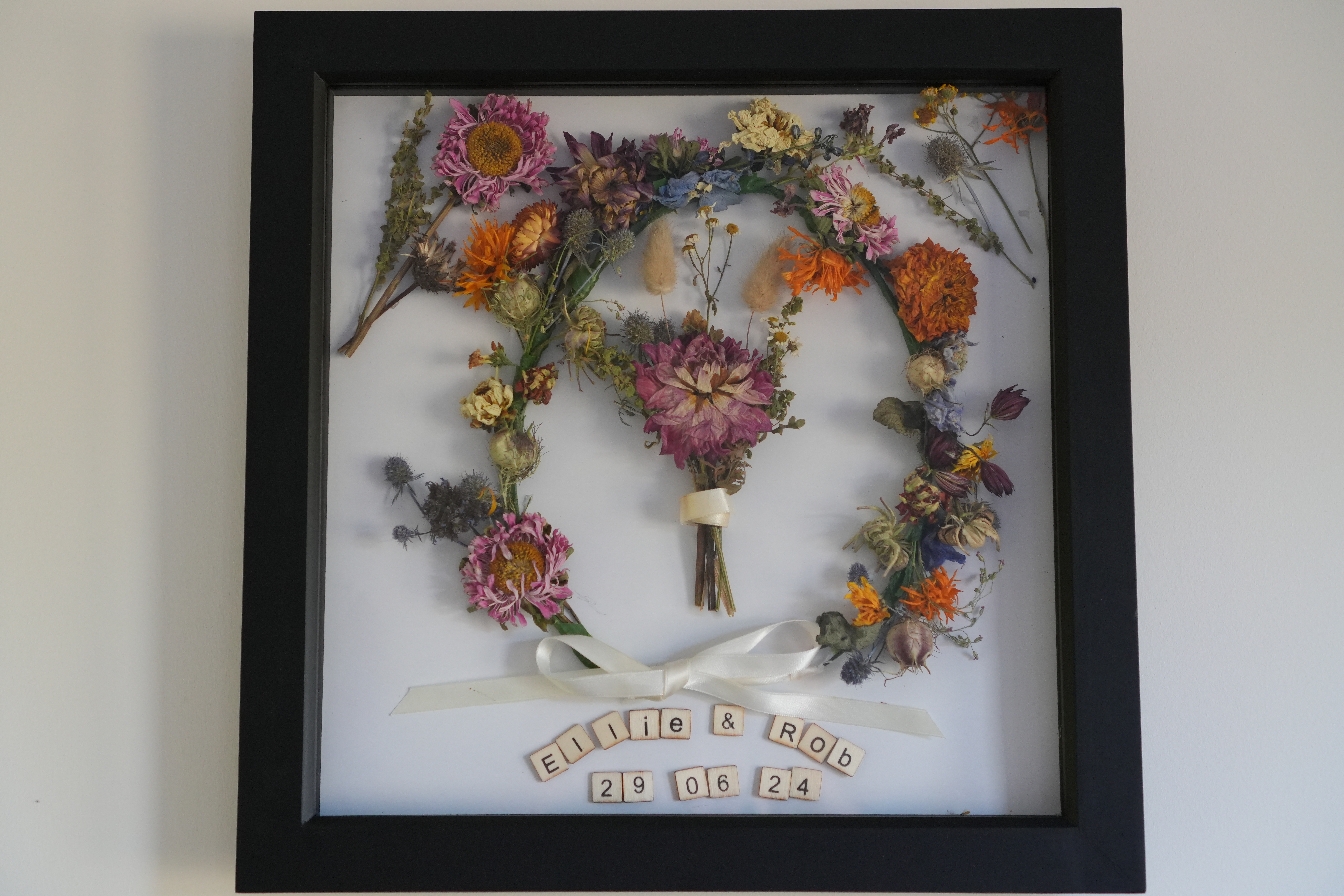 Wedding flowers beautifully preserved and displayed in a black frame