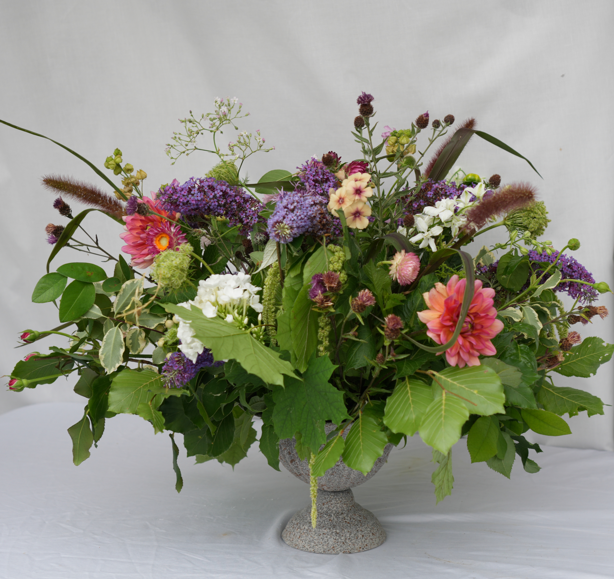 A colourful floral arrangement in a rustic urn