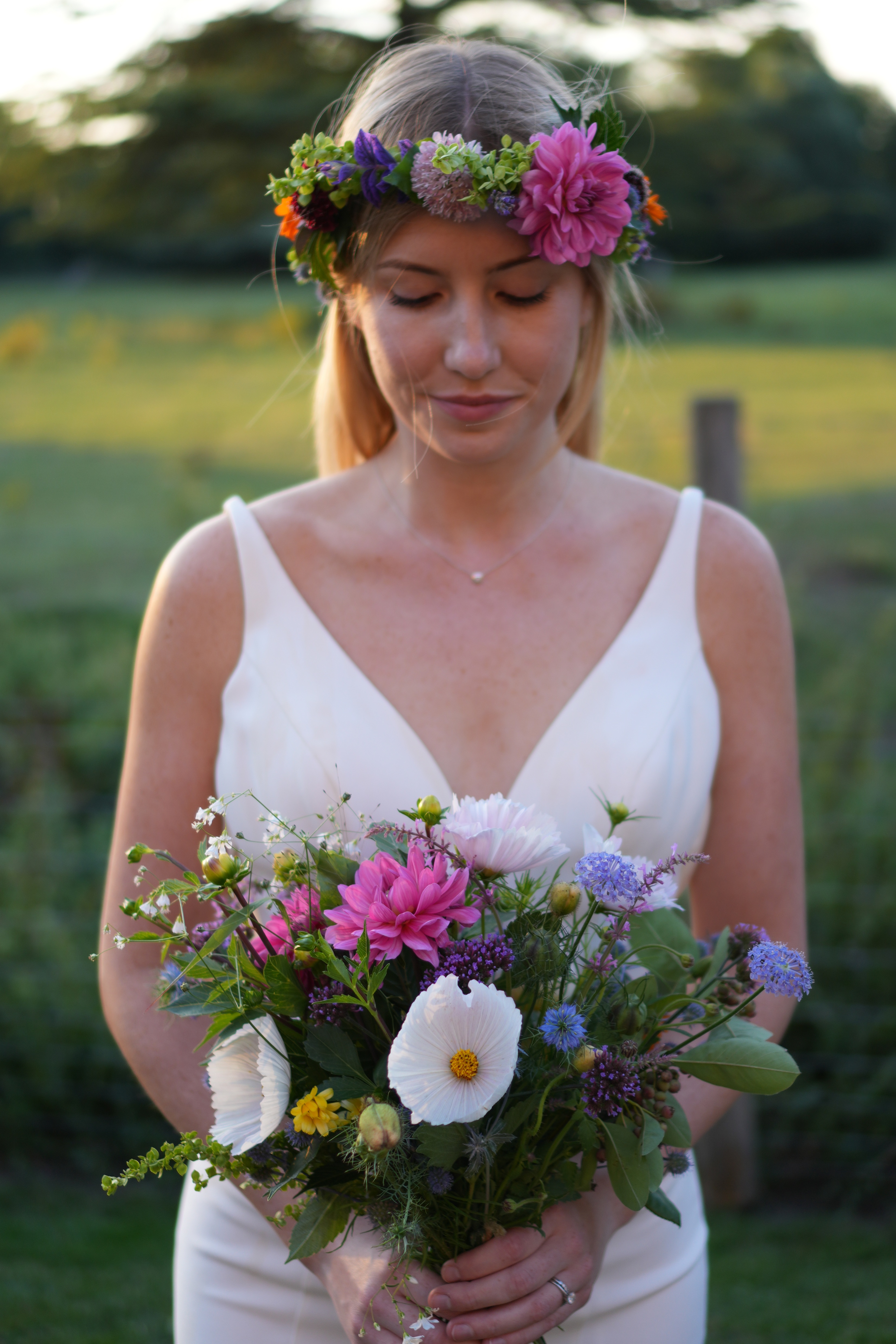 Woman facing forward, wearing a flower crown and holding a multicolour bouquet