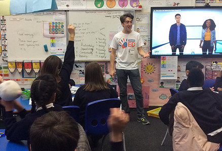 A volunteer talks about climate change to students in a classroom in London