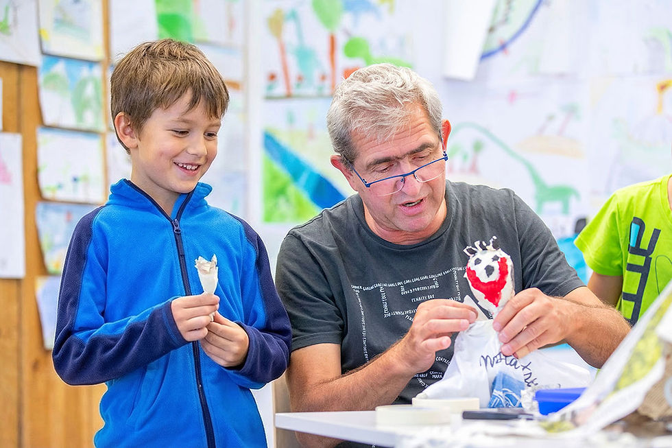 Andreas Neunhoeffer begleitet ein Kind individuell beim Gestalten im Semesterkurs – Atelier im Hinterhof Fürth