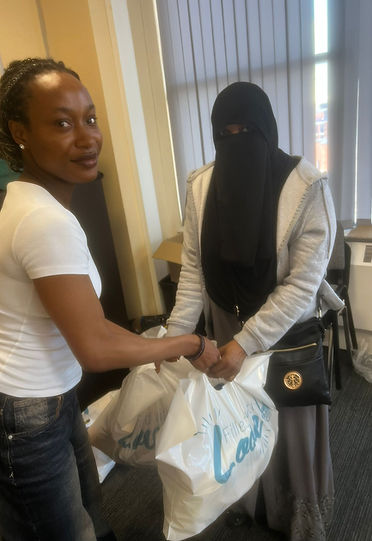 Woman hands white bag to another woman