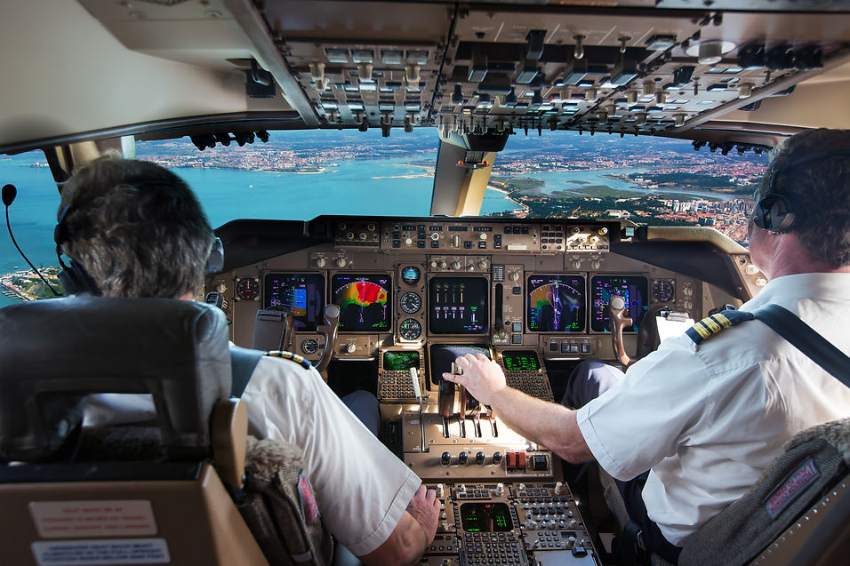 The cockpit of modern jet airplane. Aircraft flies above the city landscape and river. Pil