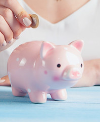 woman in white tank top holding pink pig
