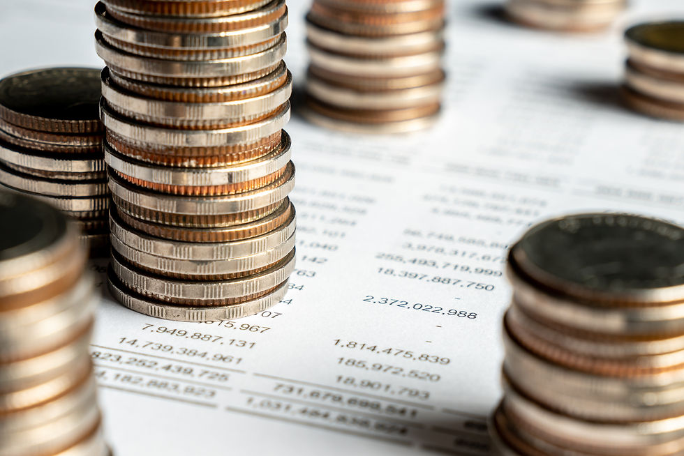 Coins stacked on a paper with a balance sheet.