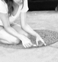 Patricia crochète un tapis au sol