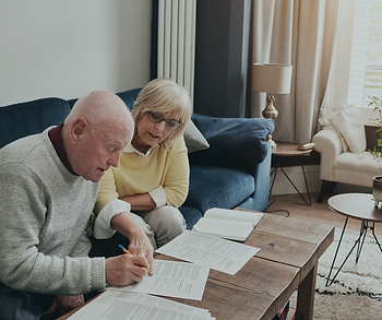 Senior couple reviewing tax documents together at a kitchen table, highlighting the federal senior tax deduction available for taxpayers age 65 and older.