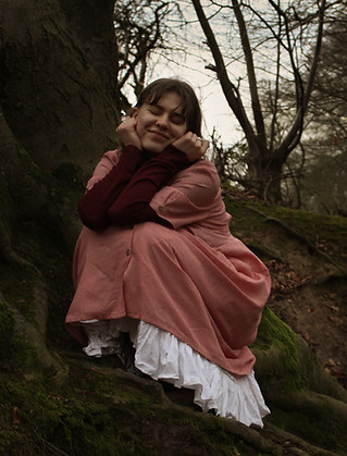 Portrait von einer jungen Frau im Wald die lächelt