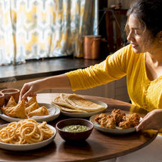 Woman setting up Indian snack tasting at home