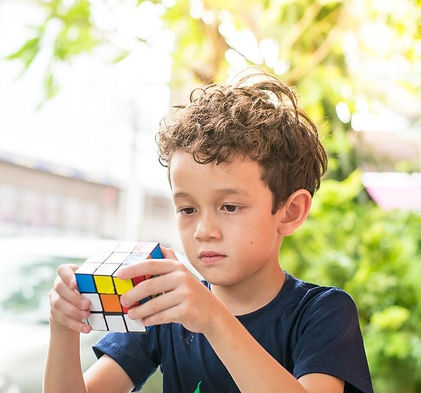 A imagem a direita mostra uma criança brincando com um cubo mágico
