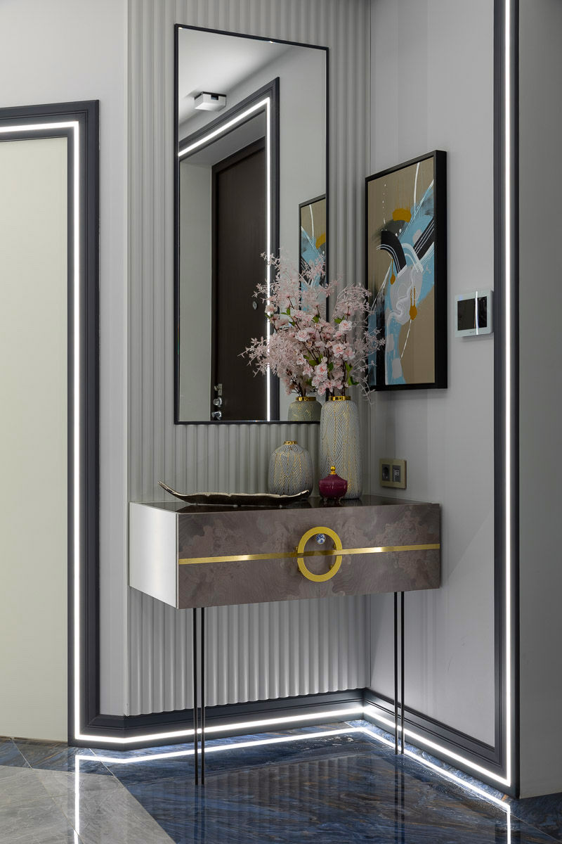 Bespoke hallway console with brass details, fluted wall panels, contemporary artwork and architectural lighting in the Northern Spring apartment interior
