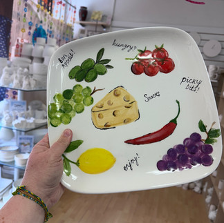square platter painted with olives and other tapas