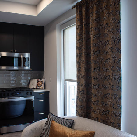 Model apartment unit kitchen/living room. Picture is taken to feature the manually operated window shade