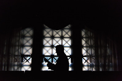 silhouette of a groom while getting dressed on his wedding day