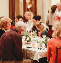 a brightly lit indoor party with people eating at the table