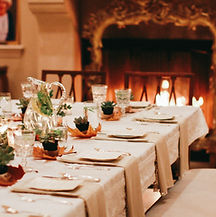 a holiday tablescape with moody lighting and a lit fireplace