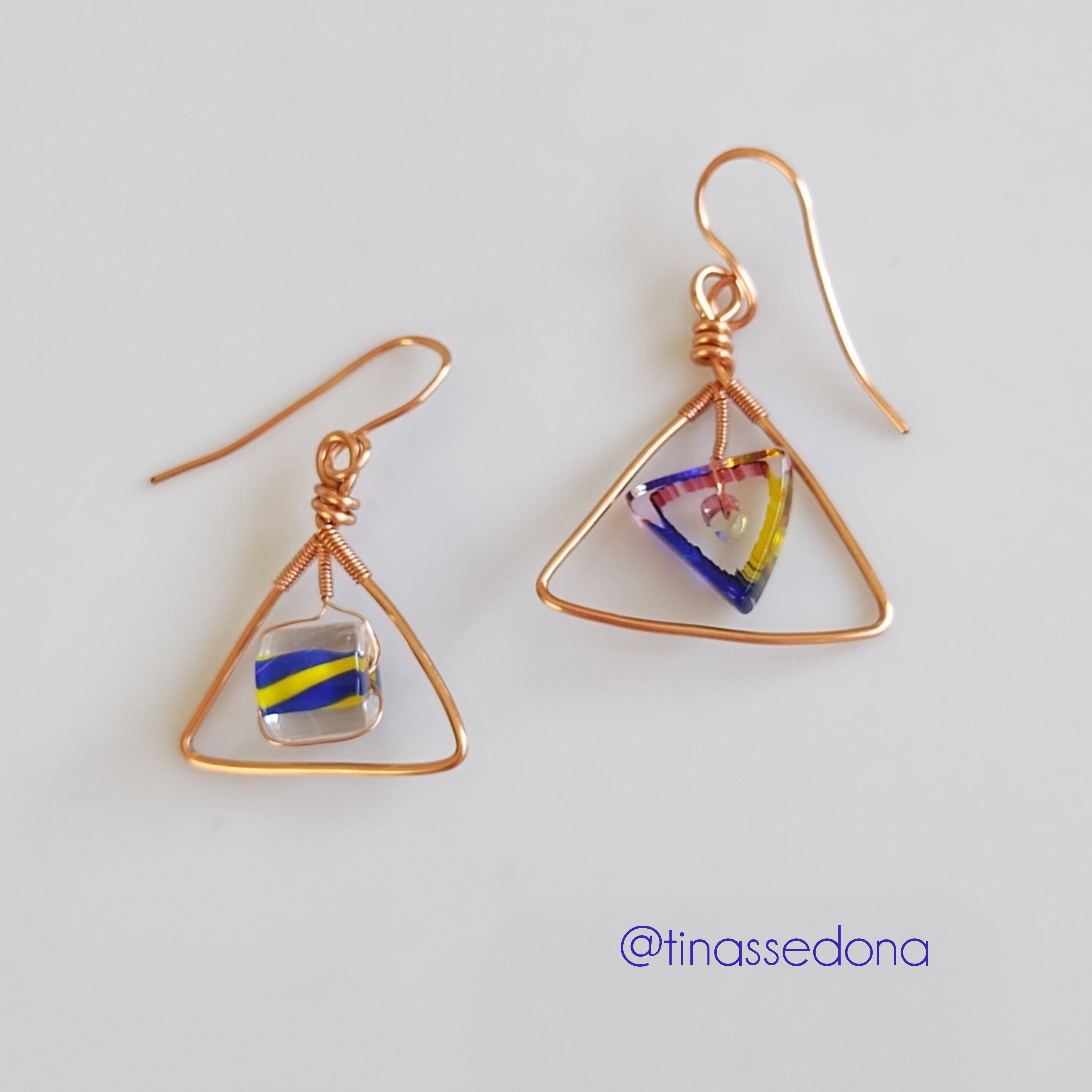 Handmade earrings of fired glass on copper triangles