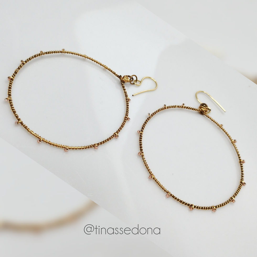 Handmade earrings of golden bronze with blush glass