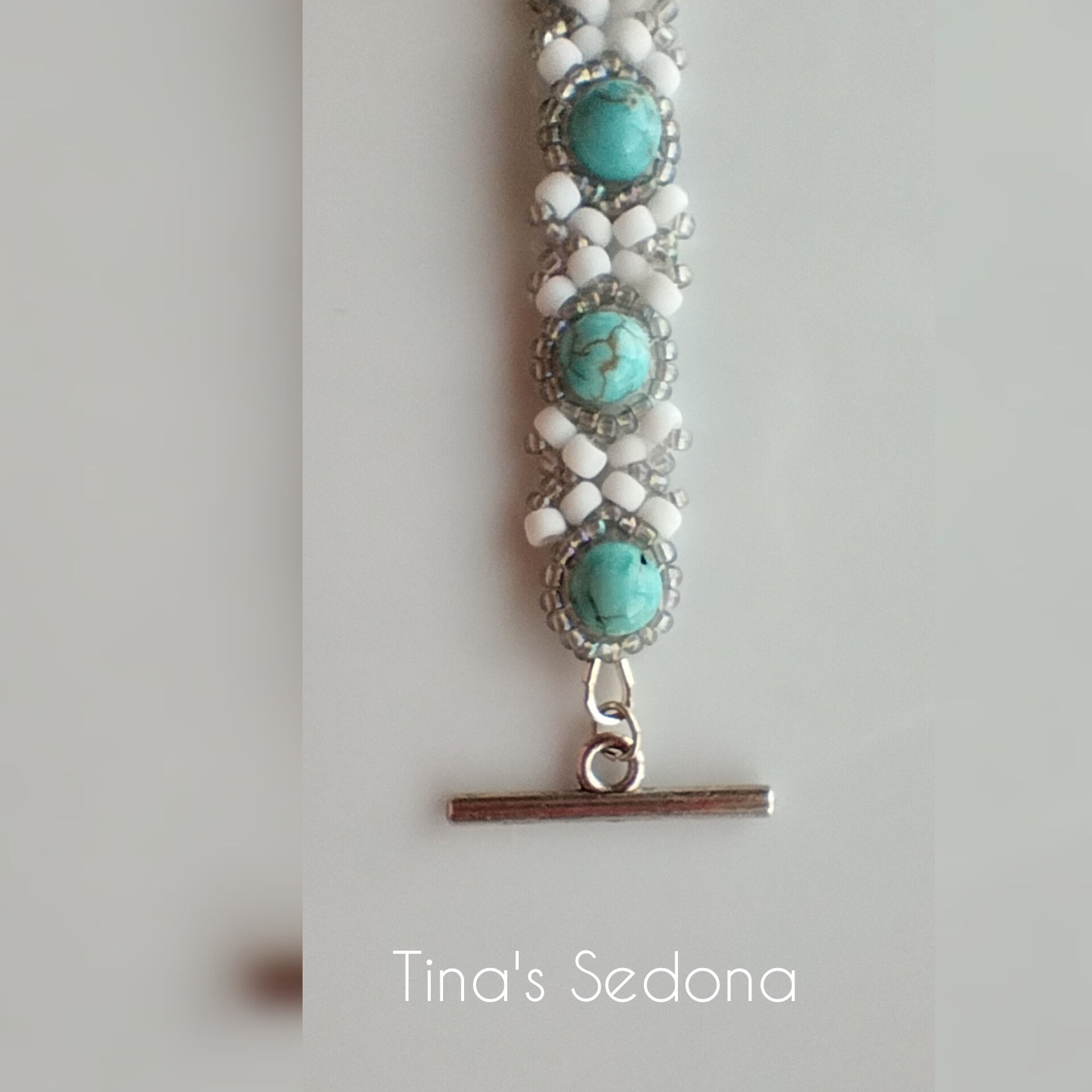 Hand woven bracelet of white and grey glass on turquoise howlite