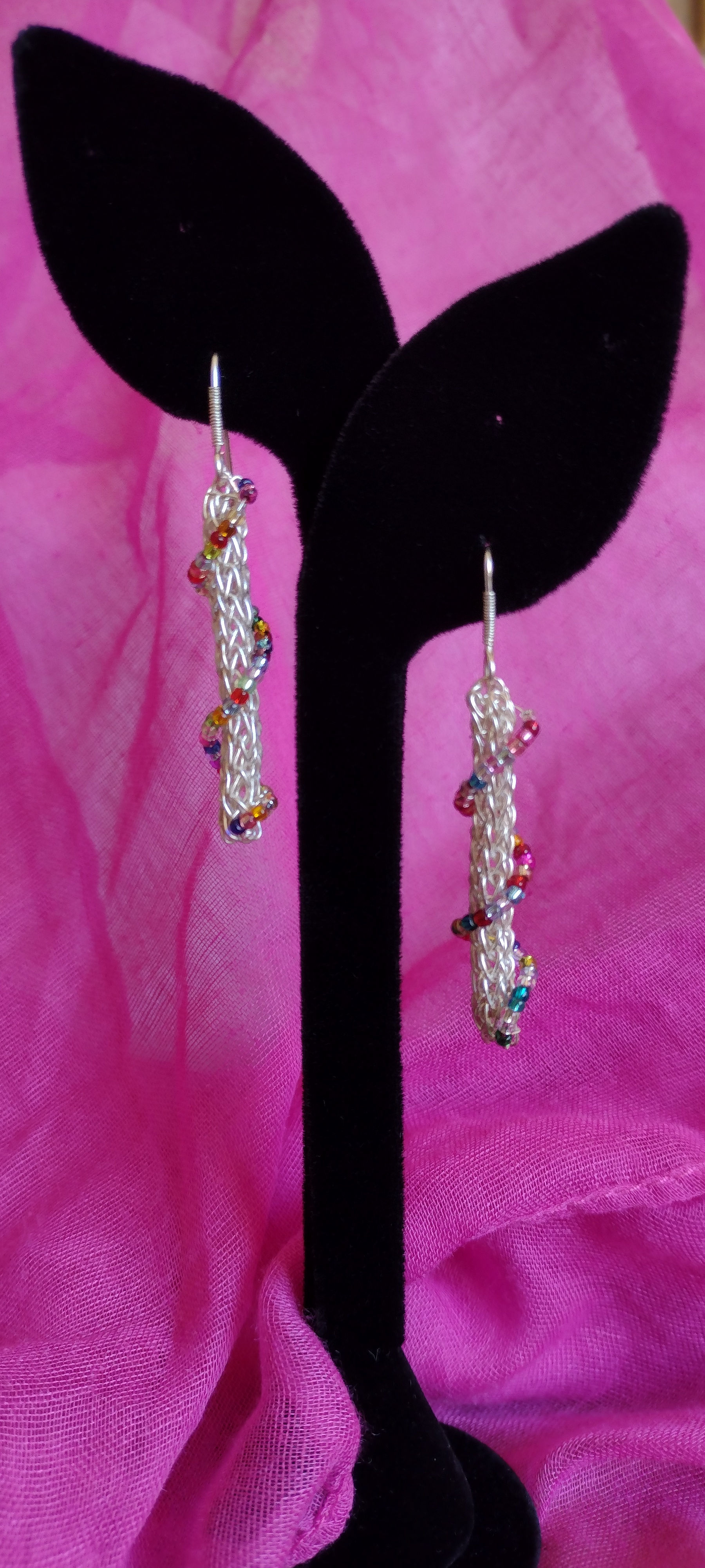 Handmade earrings of colored glass bead spiral on knitted silver