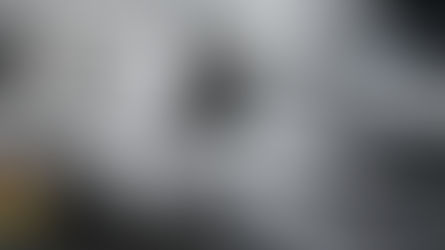 Fone de ouvido Xiaomi em cima de uma mesa cinza com um laptop