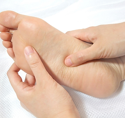 two hands applying pressure to a foot