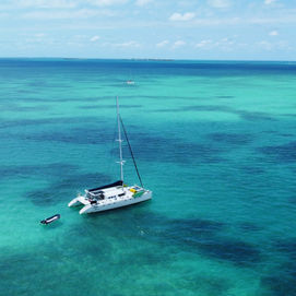 Catamaran sailboat Adonai in the beautiful blue Sea of Abaco, by Josh Stoneman