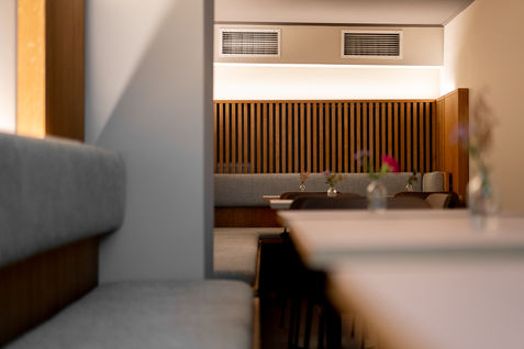 Sitzgruppe aus Holz, gepolstert mit Lamellenrückwand und Tischen