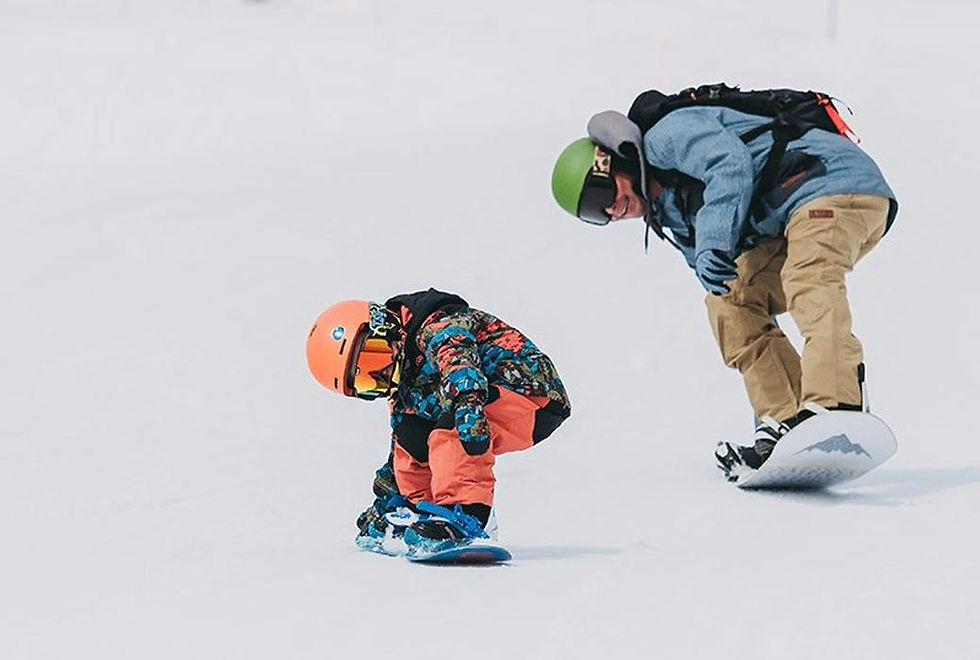 the father teaching snowboarding to his child