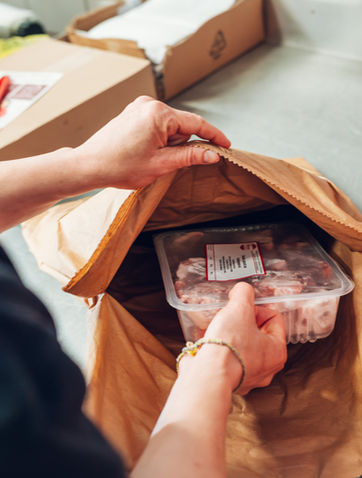 Einpacken von frischem Fleisch in eine Papiertüte