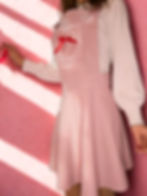Dusty pink corduroy pinafore skater dress with a high-waisted fit and embroidered heart bib pocket.