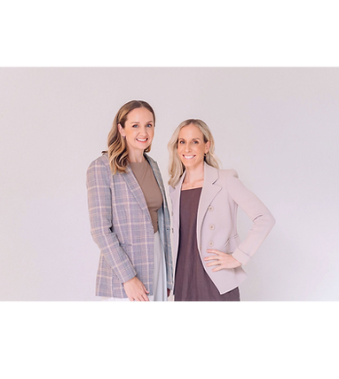 Dr. Laura Walter and Kate Bradforde standing side by side in the Pearl Menopause clinic, both wearing soft neutral‑toned blazers, smiling in a warm, softly lit setting.