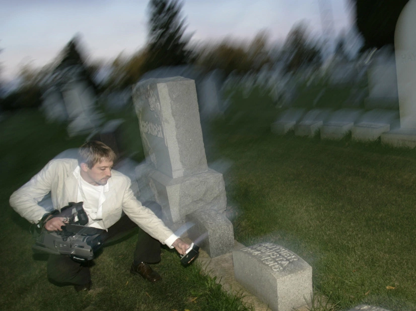 Paranormal investigator Noah Voss points a video camera at an electromagnetic frequency device to record any abnormal activity at the Sun Prairie Cemetery in Sun Prairie, Wis.  Andy Manis/AP