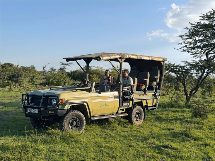 This image shows a safari vehicle used by Asilia Africa for game drives in Naboisho Conservancy, Kenya. Passengers include Spear Travel Group advisor's, Abby & Blake.
