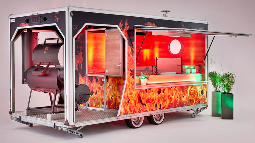 BBQ Verkaufsanhänger „Veranda Trailer – Premium BBQ“ mit 5,00 m Länge und 2,40 m Sonderbreite, tiefgelegter Achse, feuriger Folierung und professioneller Grillausstattung – mobiler BBQ-Food-Trailer mit Edelstahlküche, Holzdekor und LED-Veranda-Beleuchtung. Europaweit exklusiv bei uns erhältlich.