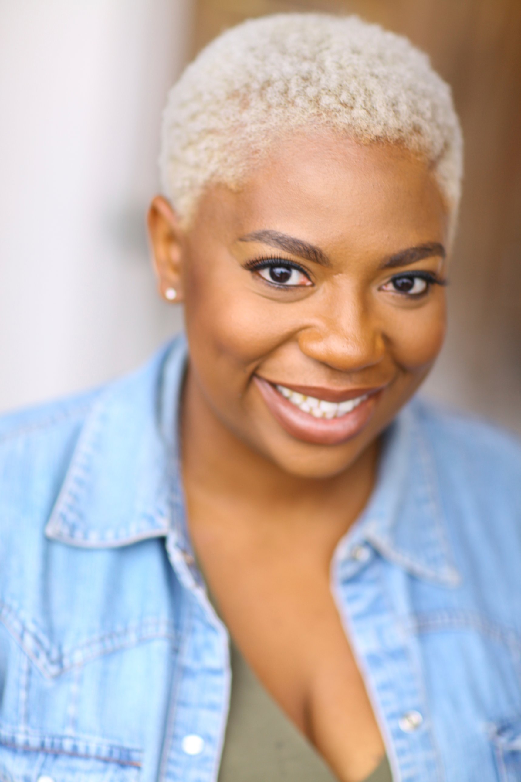 Commercial headshot of LaKesha Glover with platinum hair in denim, smiling