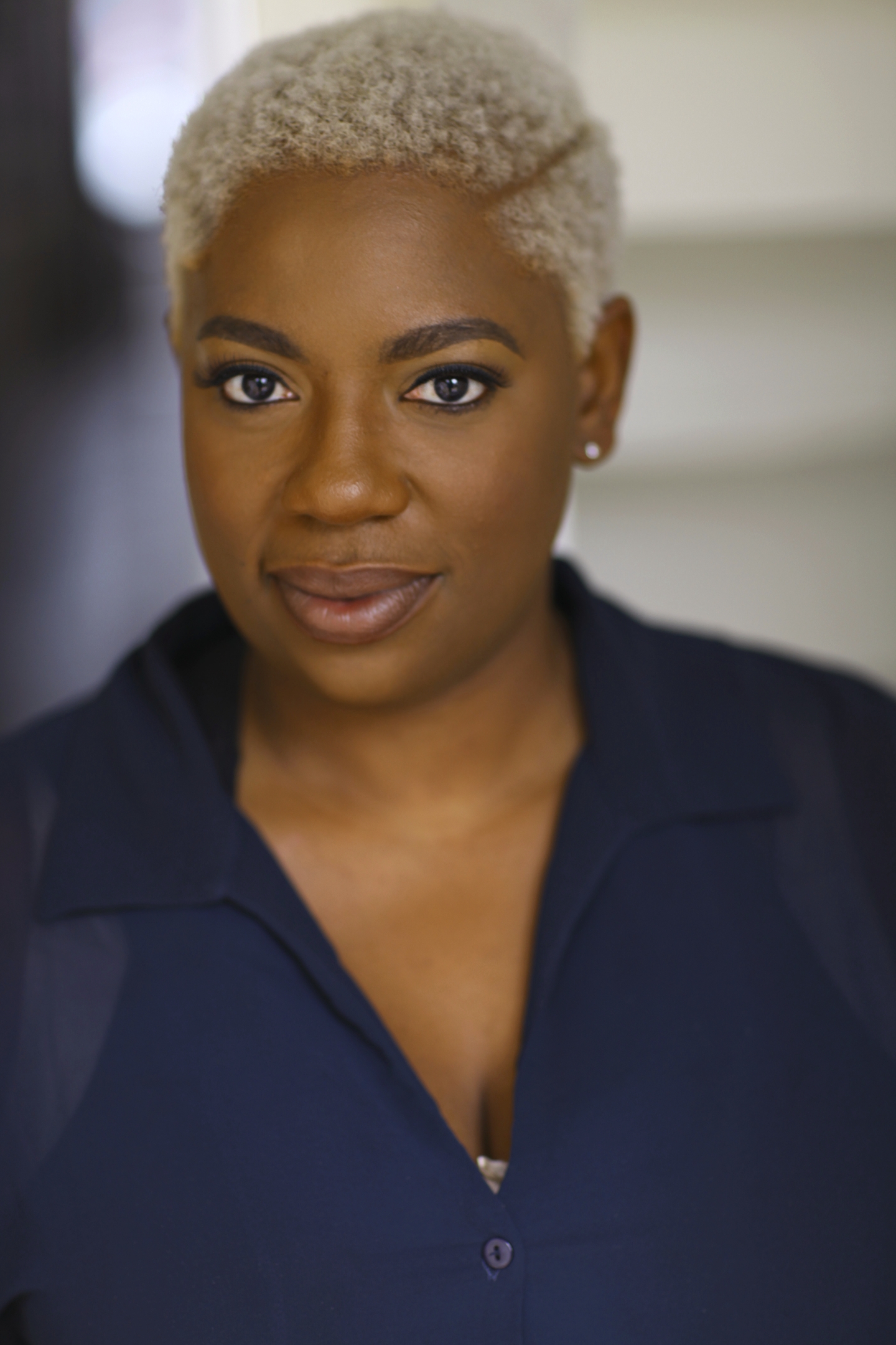 Headshot of LaKesha Glover with platinum hair in navy