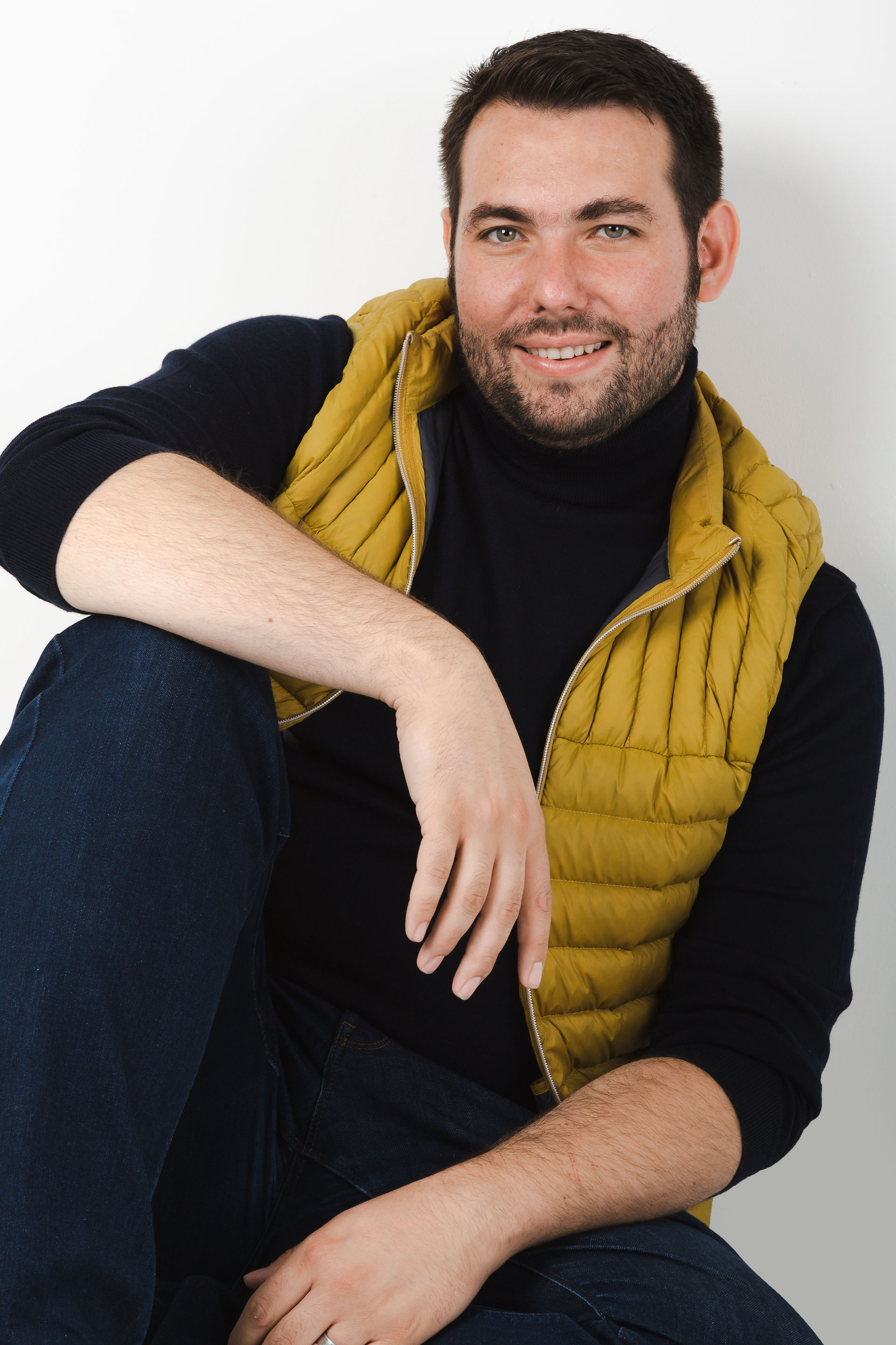 Headshot of male opera singer in mustard gillet on white background photographed in nottingham studio by Helen Boyd Photography 