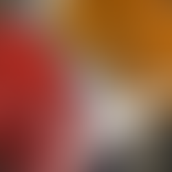 red and orange painted chickpeas on a foil lined baking sheet