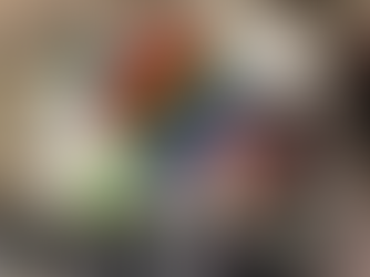 Child plays with a rainbow pop-it, black cauldron, and green duck on a high chair. Background is wooden and neutral-toned.