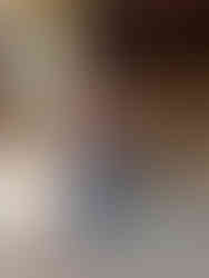 Boy in maroon shirt aiming a toy rifle in a carnival shooting gallery. Wooden background with "20 SHOTS for $1" sign. Focused mood.