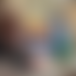 Colorful sensory toys and alphabet blocks in trays on a wooden table. Includes pom-poms, twisty tubes, and vibrant rings. Relaxed mood.