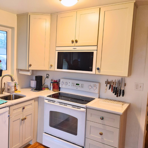 Updated kitchen cabinetry with fresh paint, new drywall and installed counter tops