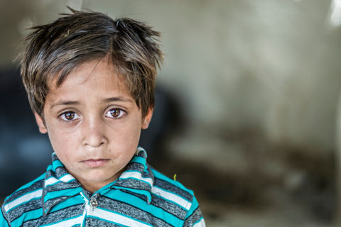 Young boy with dark eyes looking forward