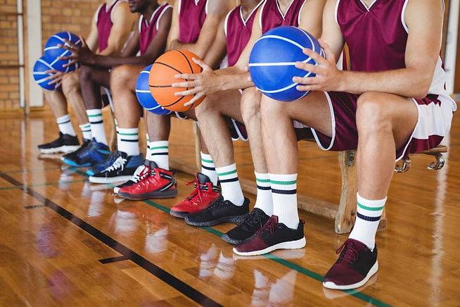basketball-players-sitting-on-bench-with-basketball.jpg
