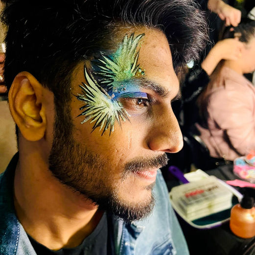 Man wears glitter makeup and face paint 