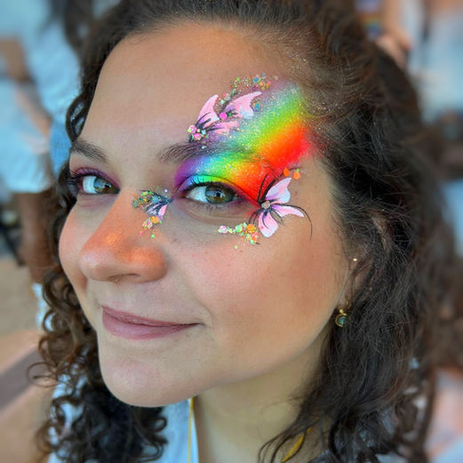 Lady wears rainbow glitter makeup and face paint 