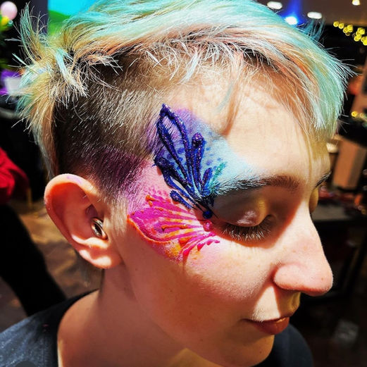 Person wears glitter makeup and face paint 