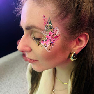 Lady wearing floral, glitter face paint