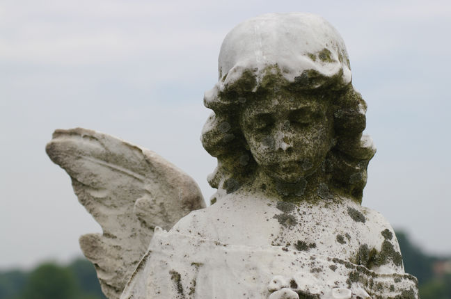 A well-worn statue in a cemetery.